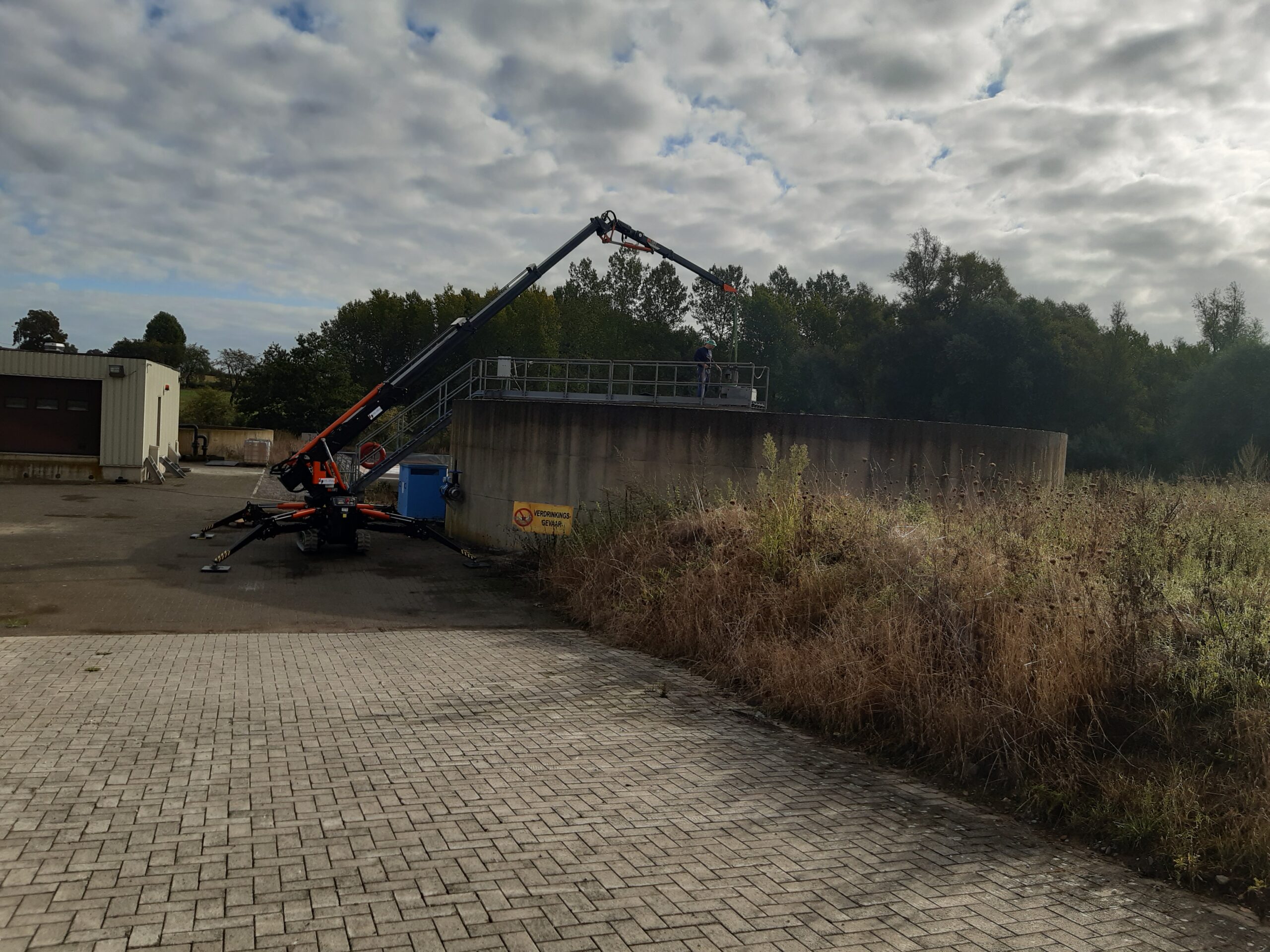 Minihijskraan bij industrieel gebouw