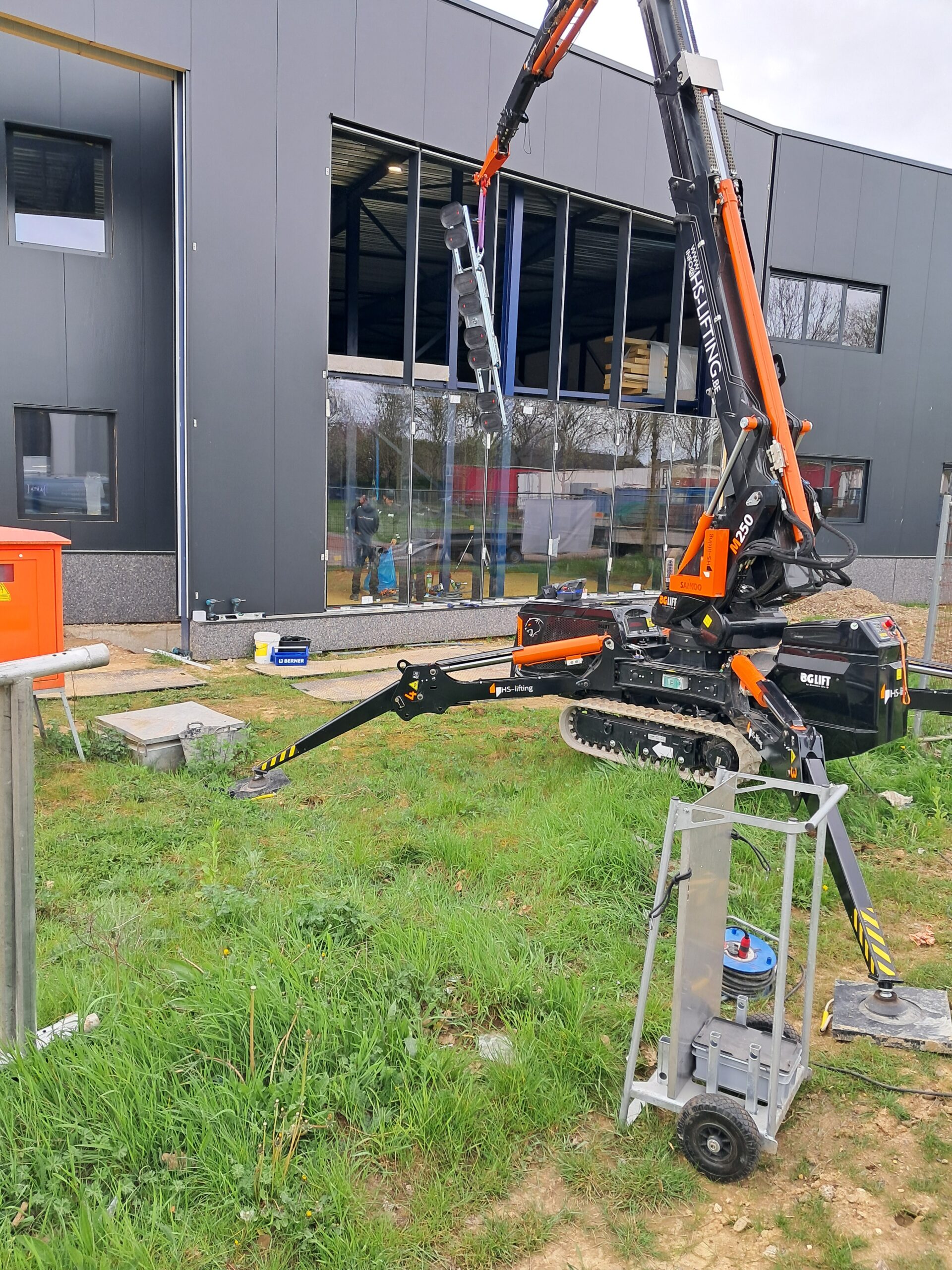 Minihijskraan plaatst houten balken